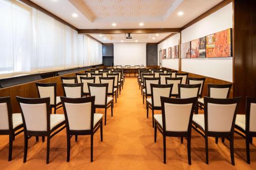 a lecture hall with rows of chairs and a whiteboard at Best Western Gorizia Palace in Gorizia