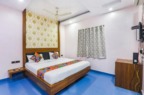 a bedroom with a large bed and a television at FabHotel Astor in Gaya