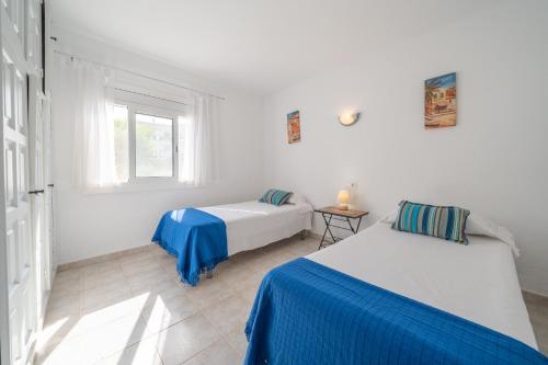 a white room with two beds and a window at Villa Sharon in L'Escala
