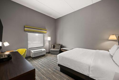 a hotel room with a bed and a desk and chair at Hampton Inn & Suites Poughkeepsie in Spackenkill