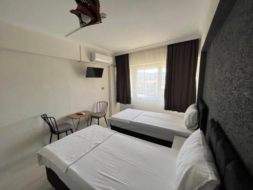 a hotel room with two beds and a table and chairs at Nobel Boutique Hotel in Selçuk