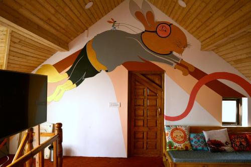 a wall with a painting of a mouse on it at Utopia Hostels Dharamkot Mcleodganj in Dharamshala