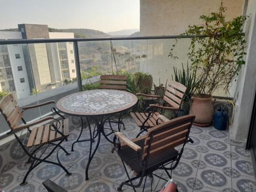 a patio with a table and chairs on a balcony at דירה נעימה בבנין הקהילתי הירוק in Harish