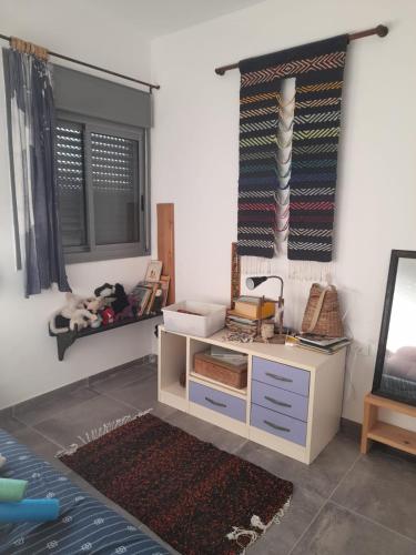 a room with a desk and a mirror and a window at דירה נעימה בבנין הקהילתי הירוק in Harish