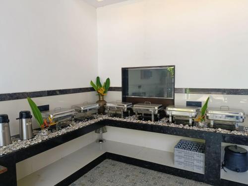 a kitchen with a counter with a tv on a wall at UVA Sands Beach Resort in Kundapur