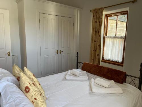 a bedroom with a bed with two towels on it at Lairds and Keepers Apartments in Dunkeld