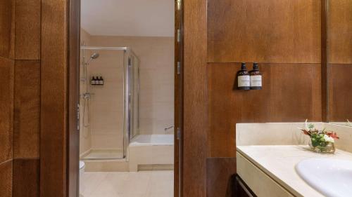 a bathroom with a sink and a shower and a tub at NH Collection Palacio de Aranjuez in Aranjuez