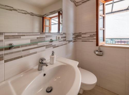 uma casa de banho branca com um lavatório e um WC em Matisse Cantone em Nerano
