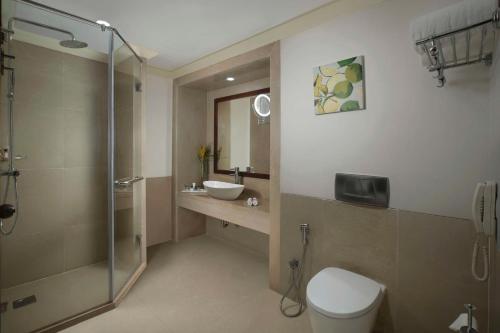a bathroom with a toilet and a sink and a shower at Radisson Blu Resort, Goa in Cavelossim