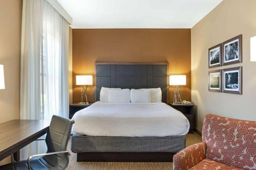 a hotel room with a bed and a desk and a chair at La Quinta by Wyndham Boone in Boone