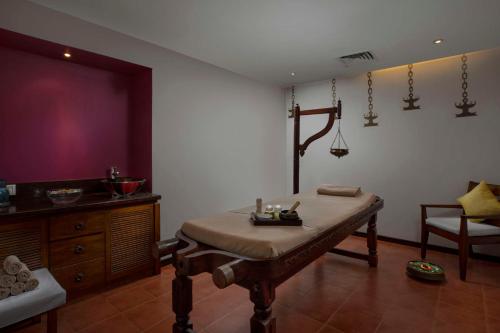 a room with a table and a bench in it at Radisson Blu Resort, Goa in Cavelossim