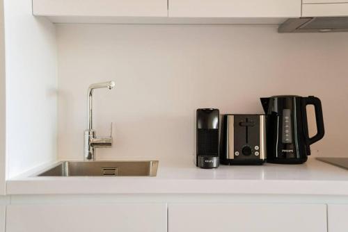 a kitchen counter with a coffee maker and a sink at Classy Studio near Thermal Spa in Vienna