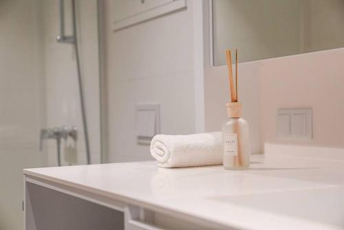 a white bathroom with a roll of toilet paper and a bottle at Classy Studio near Thermal Spa in Vienna