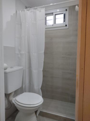 a bathroom with a white toilet and a window at Kuka 2 in Villa Gesell