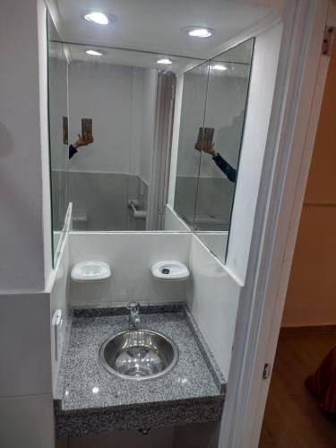 una persona que toma una foto de un lavabo en un baño en Kuka 2, en Villa Gesell