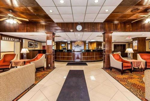 a lobby with a waiting area with orange chairs at Wingate by Wyndham Marietta Conference Center Ohio in Marietta