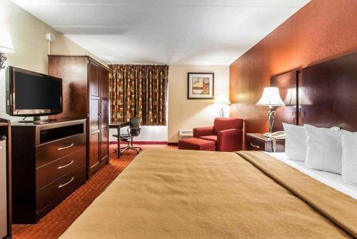 a hotel room with a bed and a flat screen tv at Wingate by Wyndham Marietta Conference Center Ohio in Marietta