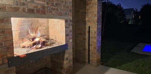 a brick fireplace with a fire in it at Sherry's Cottage in Riebeek-Kasteel