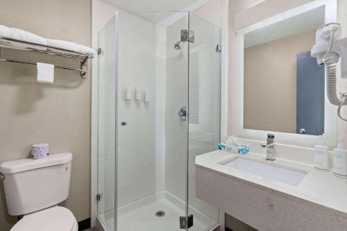 a bathroom with a shower and a toilet and a sink at Days-Inn by Wyndham Albuquerque I-25 in Albuquerque