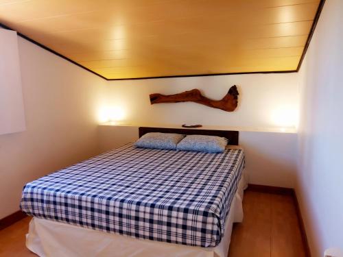 a bedroom with a bed with a checkered blanket at El Cerezo in Torre del Compte