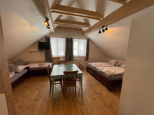 a room with a table and two beds and a table and chairs at Chata Dorotka Kvilda in Kvilda