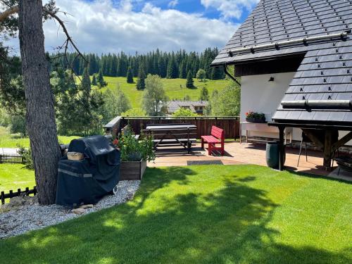 a backyard with a picnic table and a tree at Chata Dorotka Kvilda in Kvilda
