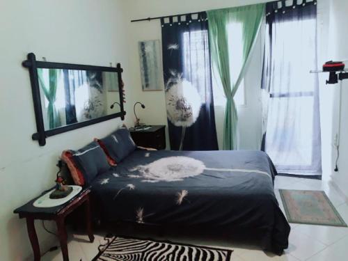 um quarto com uma cama e um espelho na parede em Room in Guest room - Nadia chamber with lounge terrace em El Jadida