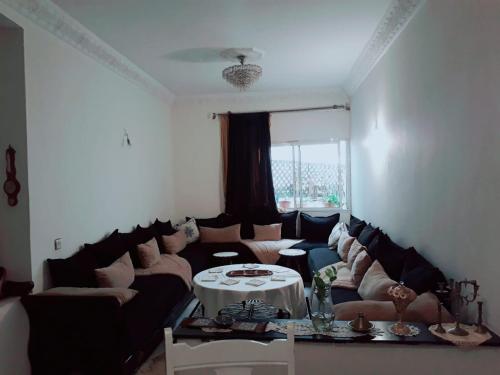uma sala de estar com um sofá e uma mesa em Room in Guest room - Nadia chamber with lounge terrace em El Jadida