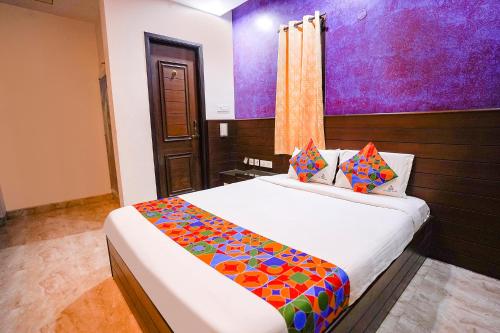 a bedroom with a large bed with a colorful blanket at FabExpress MM Residency in Chennai