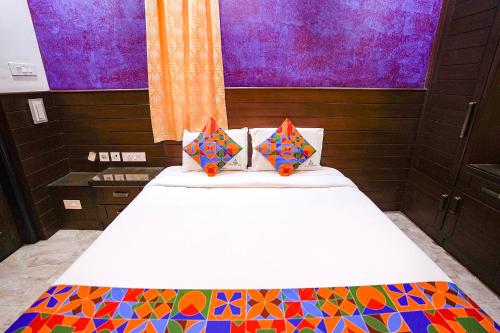 um quarto com uma cama com um cobertor colorido em FabExpress MM Residency em Chennai
