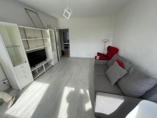 グディニャにある19 Gdynia Centrum - Apartament Mieszkanie dla 8 osのリビングルーム(灰色のソファ、テレビ付)