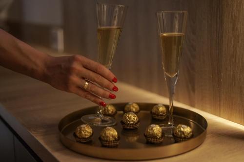 a woman with a glass of champagne and a tray of cupcakes at Apartman Herc in Trebinje