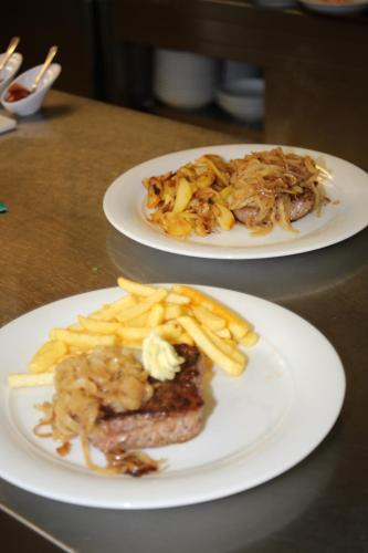 two plates of food on a table with french fries at Gasthaus Post in Goldbach