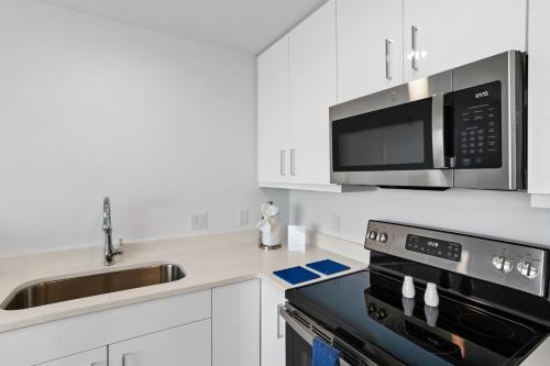 a kitchen with a microwave and a stove top oven at Ocean Club Treasure Island Hotel in St Pete Beach