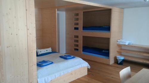a bedroom with a bed with two bunk beds at Hotel des Alpes Dalpe in Dalpe