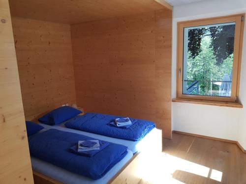 two beds in a room with a window at Hotel des Alpes Dalpe in Dalpe