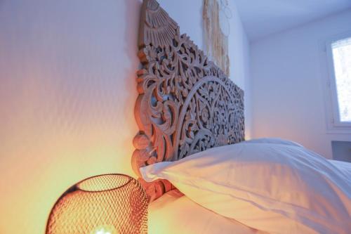 a bed with a wooden head board and a lamp at Cozy along the river - downtown & terrace - 4 in Annecy