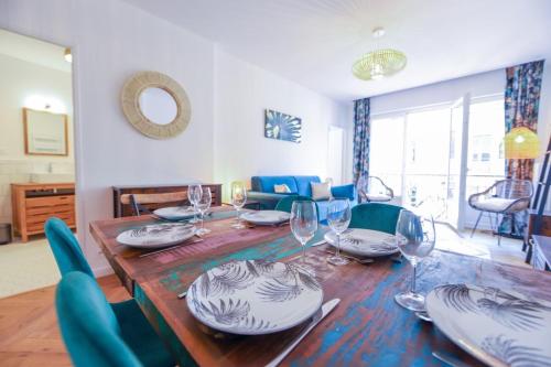 - une table à manger avec des assiettes et des verres à vin dans l'établissement Cozy along the river - downtown & terrace - 4, à Annecy