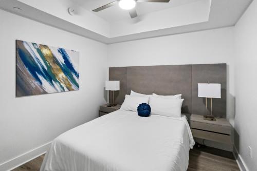 a bedroom with a white bed and a painting at Ocean Club Treasure Island Hotel in St Pete Beach