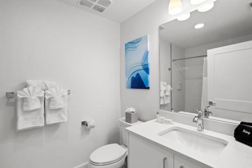 a bathroom with a sink and a toilet and a mirror at Ocean Club Treasure Island Hotel in St Pete Beach