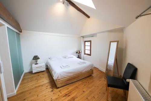 een slaapkamer met een bed, een bureau en een spiegel bij La maison verte in Annecy