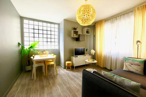 a living room with a couch and a table at Le cocon coloré - centre ville - 50m de la gare in Annecy