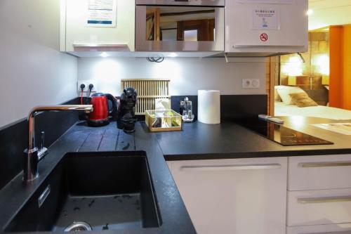 a kitchen with a black counter top and a sink at Le Cocon - Lofts & Lakes certified 4-stars in Annecy