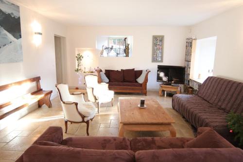 a living room with a couch and a table at Historical villa by the lake - 12 people in Doussard