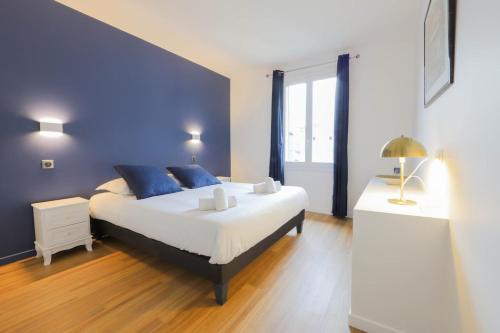 a bedroom with a large bed with blue pillows at Le Boudoir bleu - 2 chambres in Annecy
