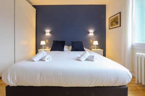 ein großes weißes Bett in einem Zimmer mit zwei Lampen in der Unterkunft Le Boudoir bleu - 2 chambres in Annecy