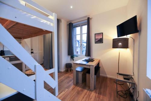 um pequeno quarto com uma secretária e uma cama alta em Le Petit Plus - studio confortable avec parking em Annecy