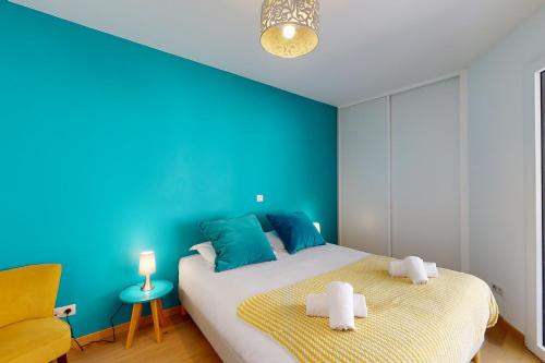 - une chambre bleue avec un lit et une chaise jaune dans l'établissement Le Trésum a few steps from the lake parking, à Annecy