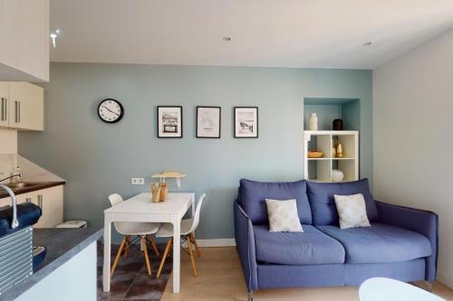 ein Wohnzimmer mit einem blauen Sofa und einem Tisch in der Unterkunft Le Royale w balcony in Annecy