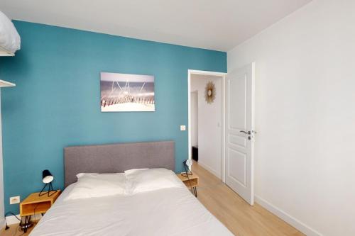 アヌシーにあるLe Royale w balconyの青い壁のベッドルーム1室、ベッド1台が備わります。